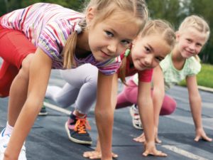 three pre-teen girls starting to run on track