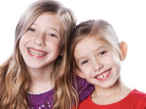 A head and shoulders image of two happy caucasian sisters.
