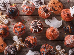 Halloween cupcakes and gingerbread cookies on the table. horizontal view from above